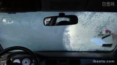 从车内看，女司机正在用刮冰器刮汽车挡风玻璃